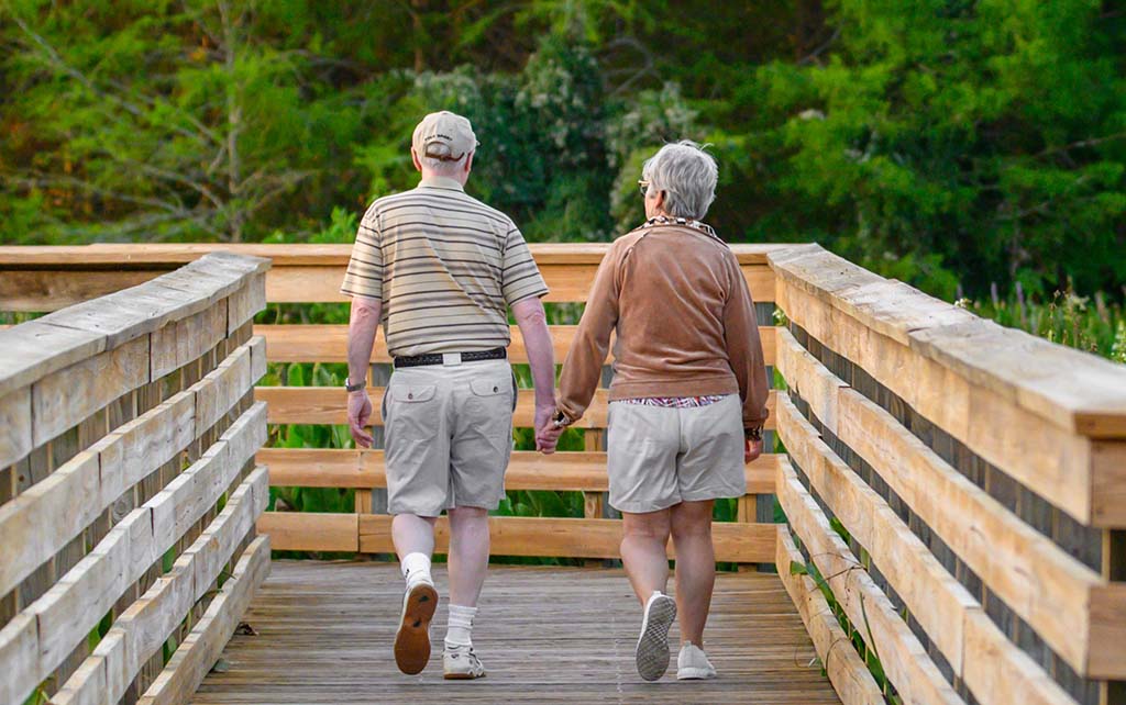 elderly couple walking holding hands
